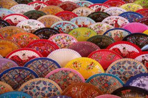 Vibrant display of traditional Spanish hand fans showcasing intricate designs in Sevilla.